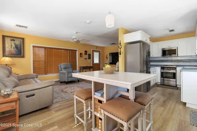 a kitchen with a table chairs refrigerator and cabinets