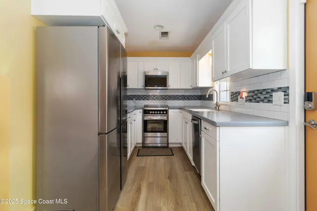 a kitchen with stainless steel appliances granite countertop a stove and a refrigerator