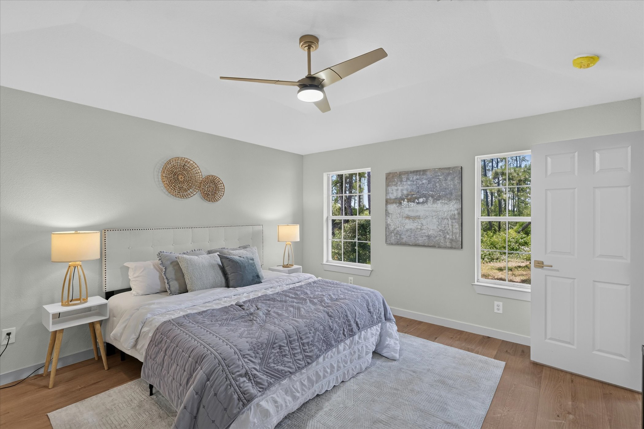 258 Pine View Loop Bastrop, TX 78602 - Photo 29 of 40 A tranquil bedroom retreat features a modern ceiling fan, rich hardwood flooring, and multiple windows.