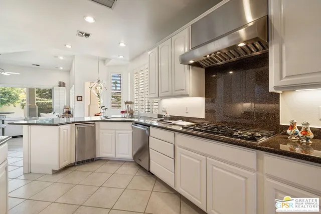 a kitchen with stainless steel appliances kitchen island granite countertop a table and chairs in it