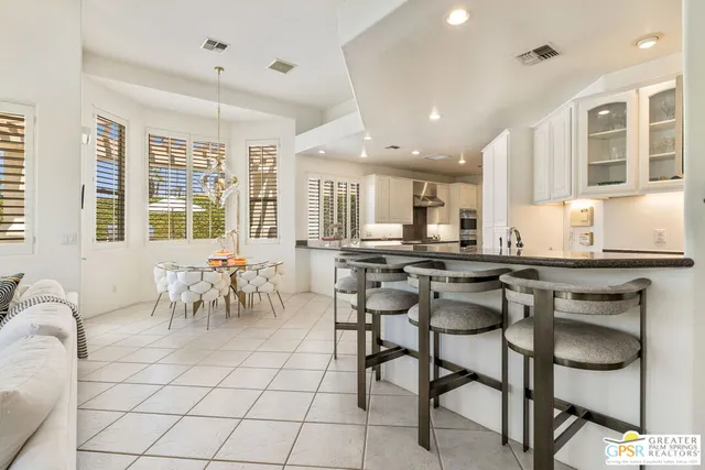 a kitchen with stainless steel appliances kitchen island granite countertop a table and chairs in it