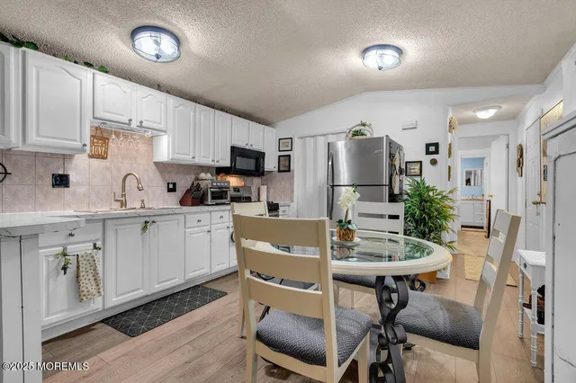 a kitchen with a table chairs refrigerator and microwave