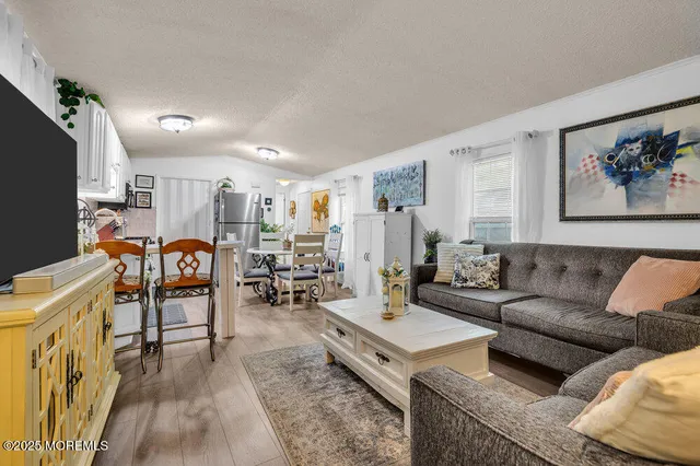 a living room with furniture kitchen view and a large window