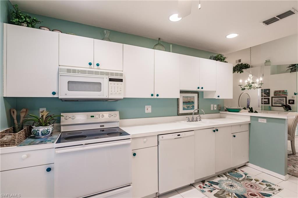 570 Windsor Square, Unit 202 Naples, FL 34104 - Photo 11 of 24 a kitchen with cabinets appliances a sink and a counter top space