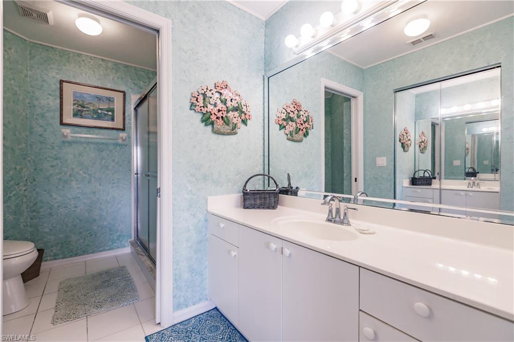 570 Windsor Square, Unit 202 Naples, FL 34104 - Photo 19 of 24 a bathroom with a sink mirror and toilet