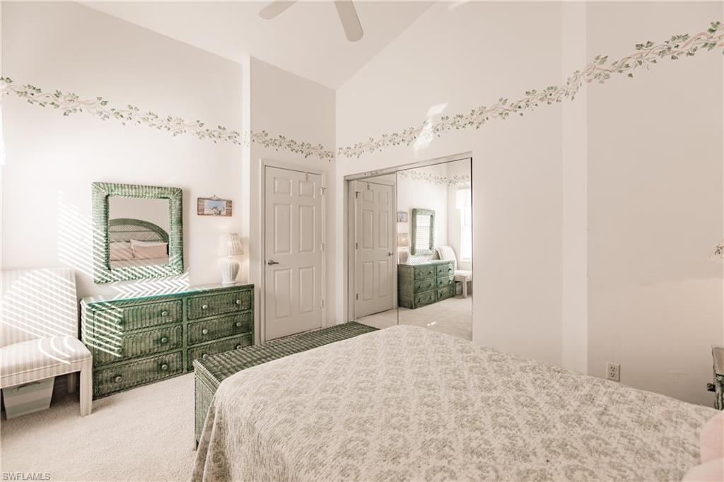 570 Windsor Square, Unit 202 Naples, FL 34104 - Photo 21 of 24 a bedroom with a bed and a dresser