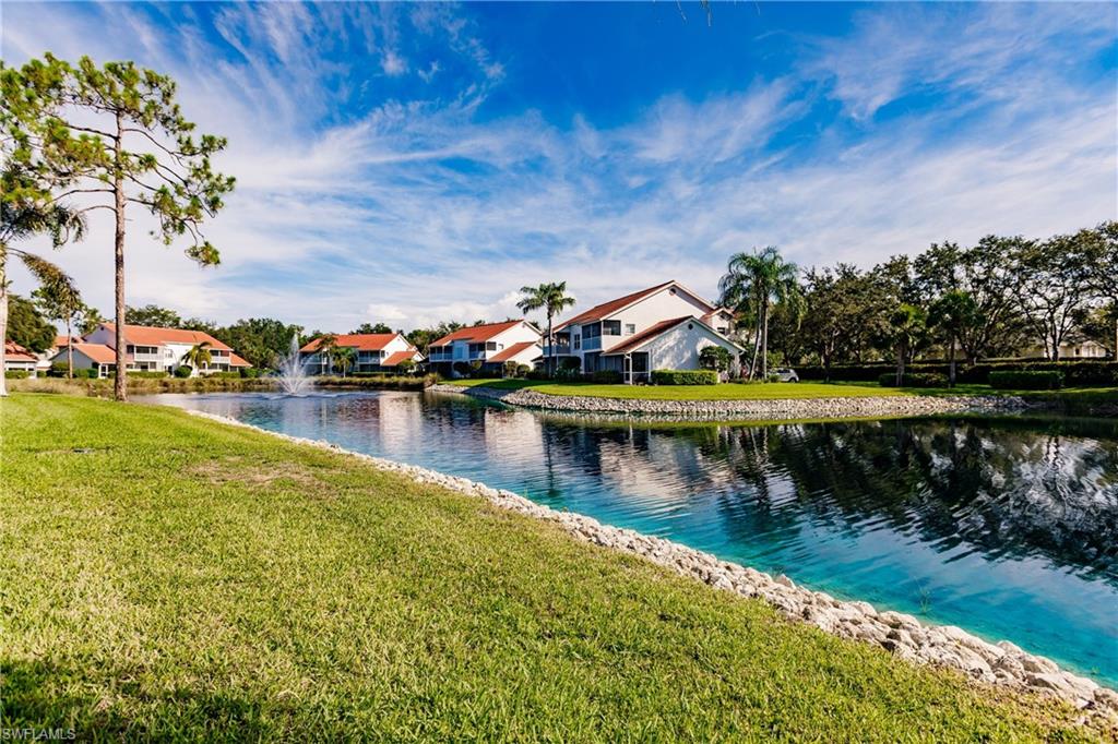 570 Windsor Square, Unit 202 Naples, FL 34104 - Photo 5 of 24 a view of a lake with houses in the back