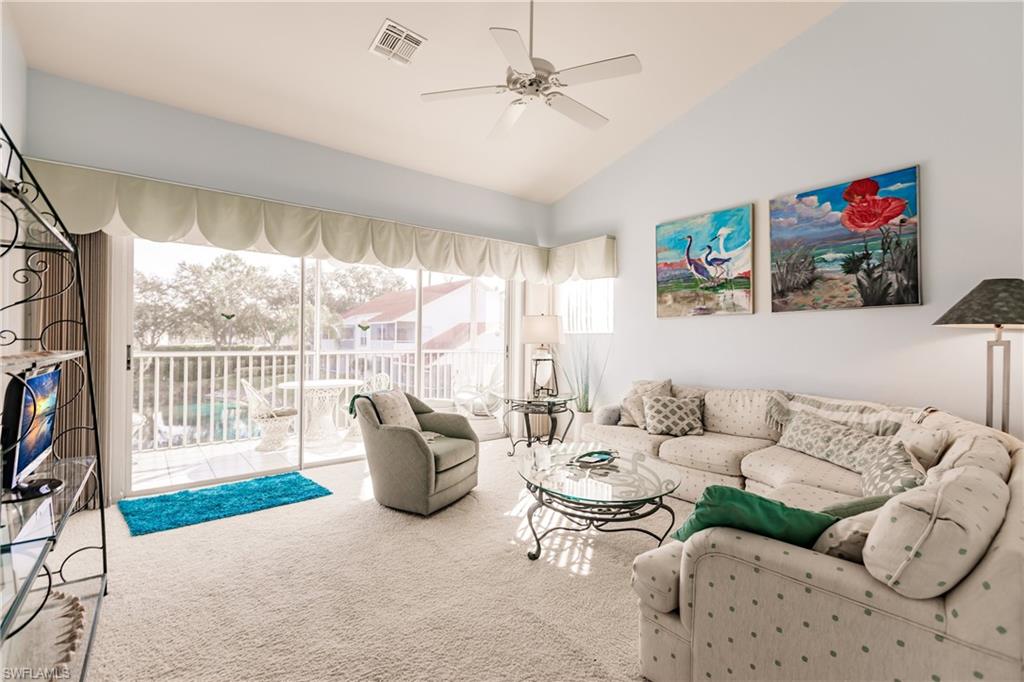 570 Windsor Square, Unit 202 Naples, FL 34104 - Photo 8 of 24 a living room with furniture and a floor to ceiling window