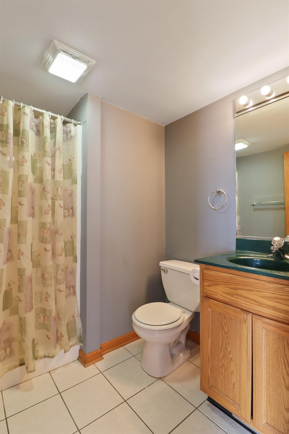 a bathroom with a granite countertop toilet a sink and a mirror