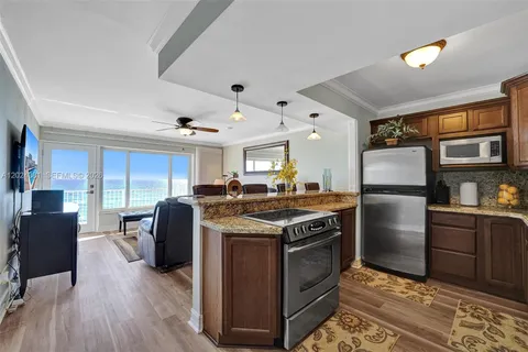 a kitchen with stainless steel appliances granite countertop a sink a stove and a refrigerator