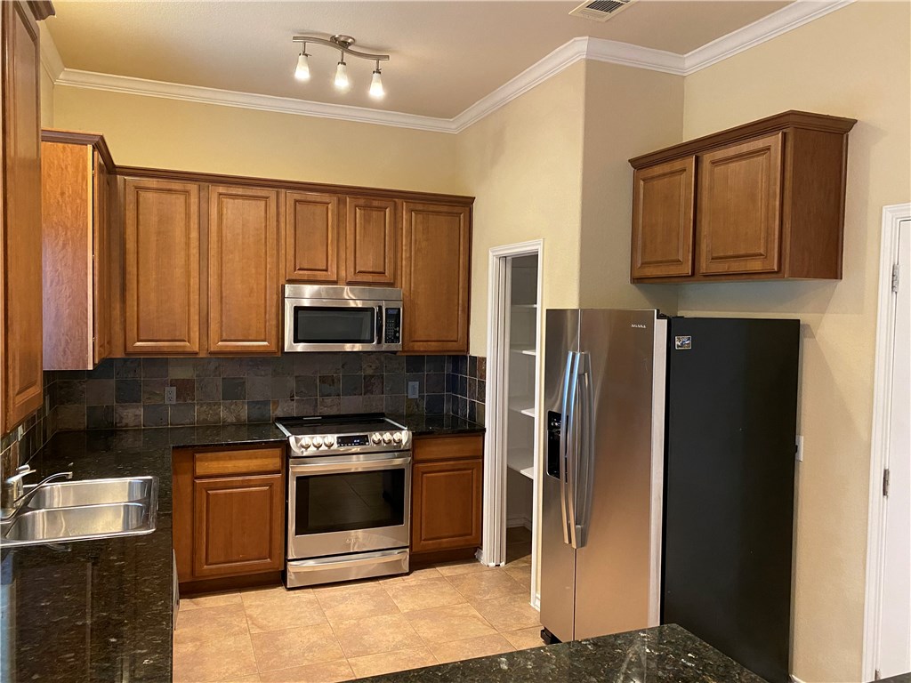 2670 Crazyhorse Pass Austin, TX 78734 - Photo 4 of 27 a kitchen with stainless steel appliances granite countertop a refrigerator stove and microwave
