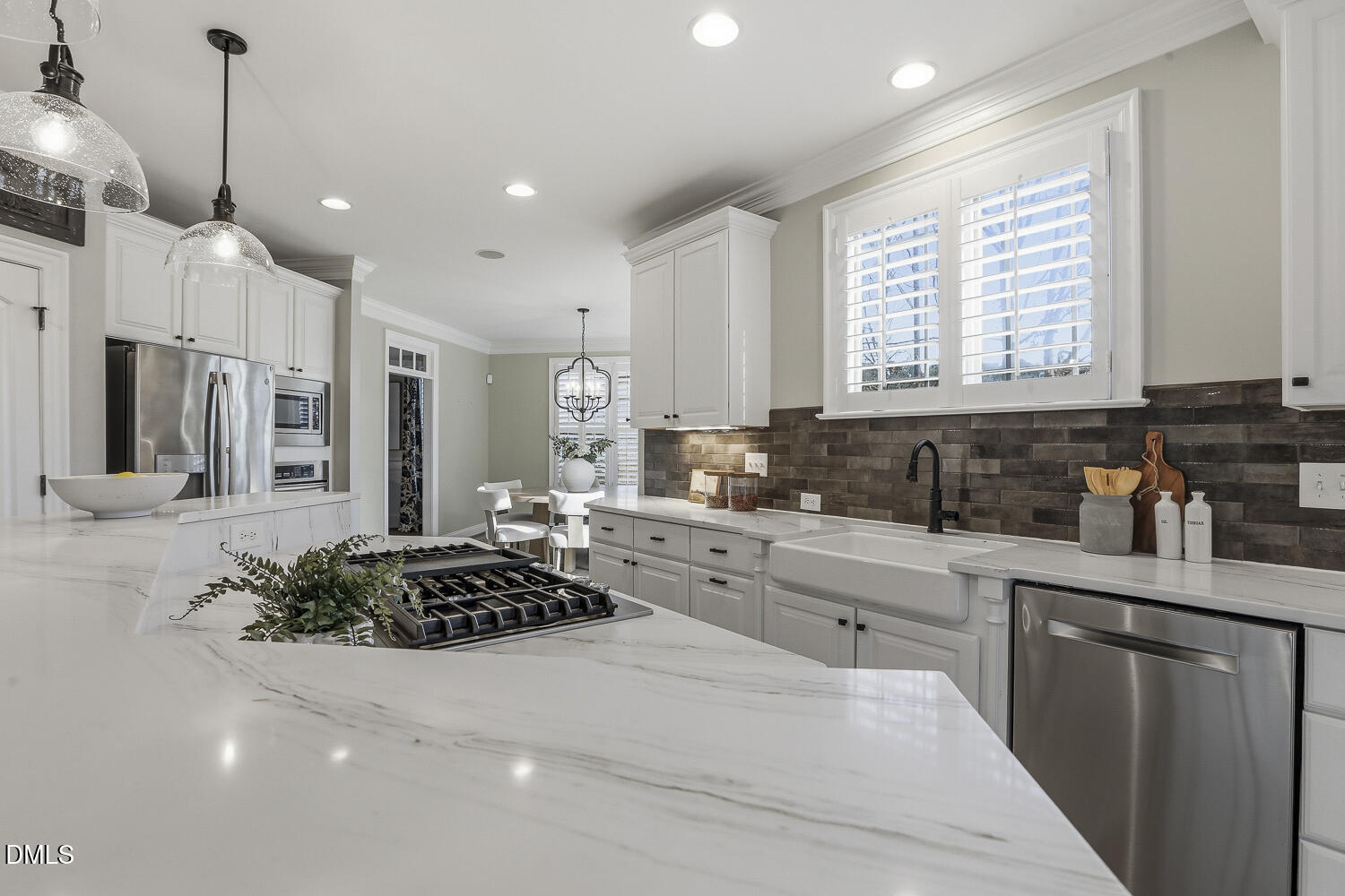 3124 Briar Stream Run Raleigh, NC 27612 - Photo 6 of 57 a large white kitchen with stainless steel appliances granite countertop a stove a sink a refrigerator and white cabinets with wooden floor