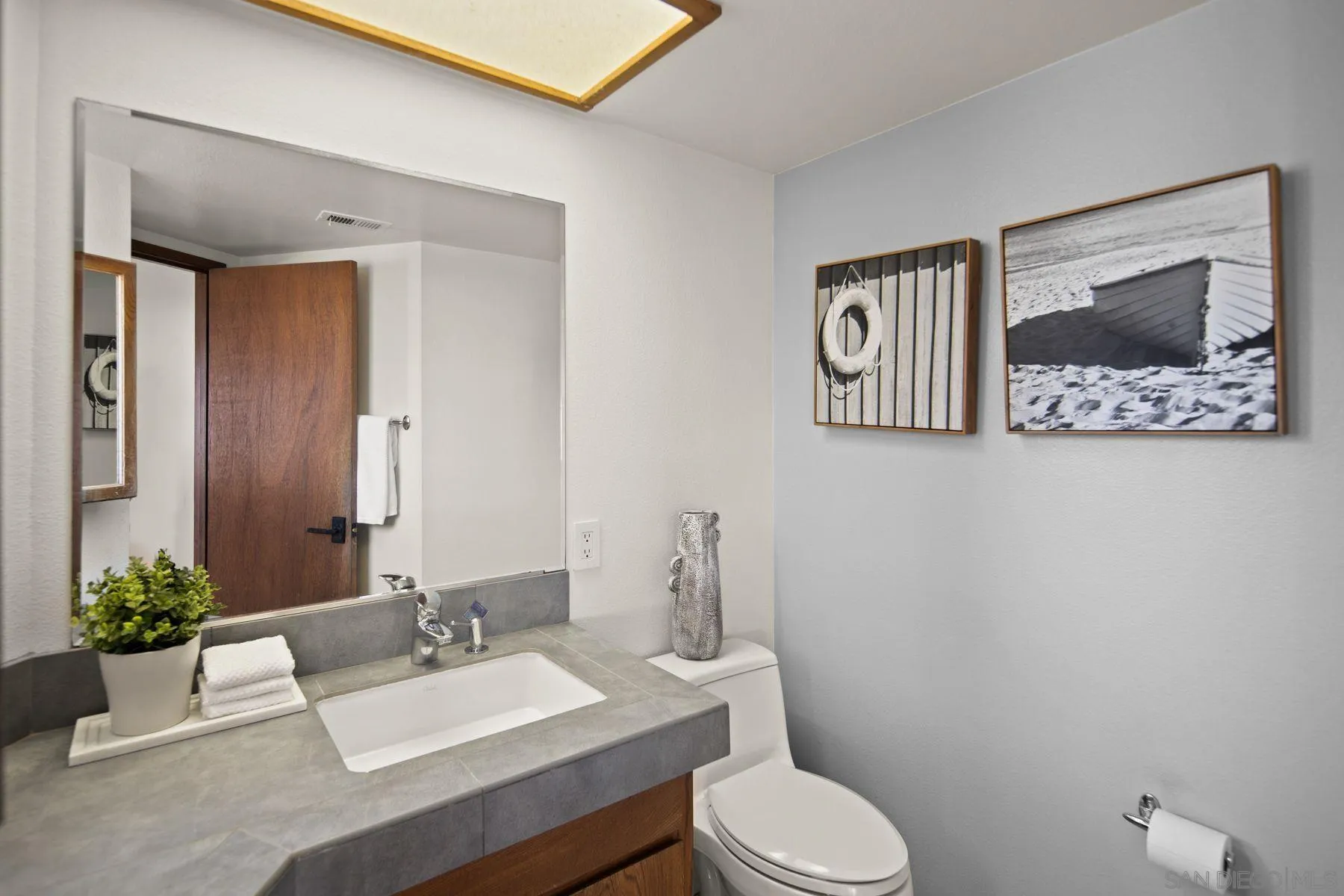 1005 Cornish Drive San Diego, CA 92107 - Photo 27 of 71 a bathroom with a toilet a sink and mirror