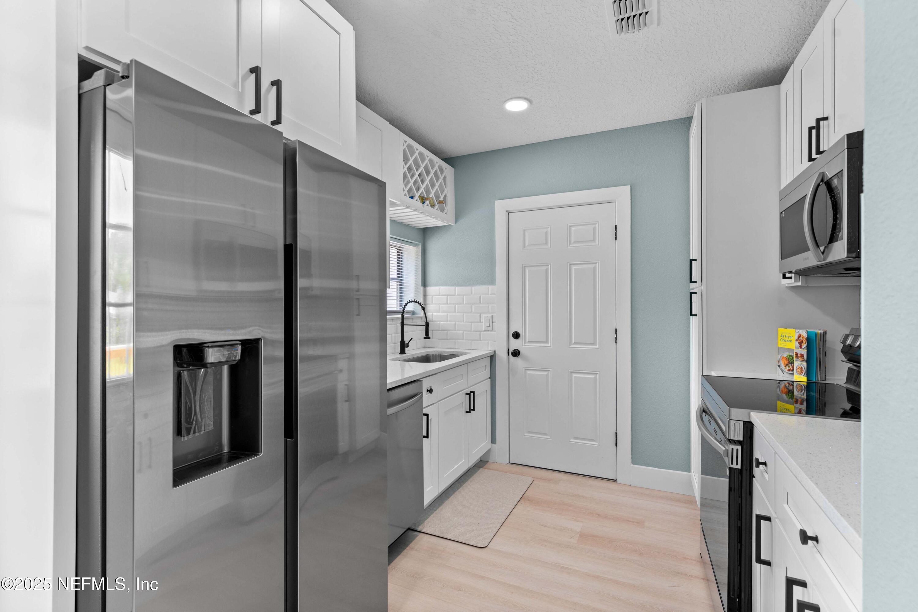 4647 Timuquana Road Jacksonville, FL 32210 - Photo 11 of 27 a kitchen with cabinets and stainless steel appliances