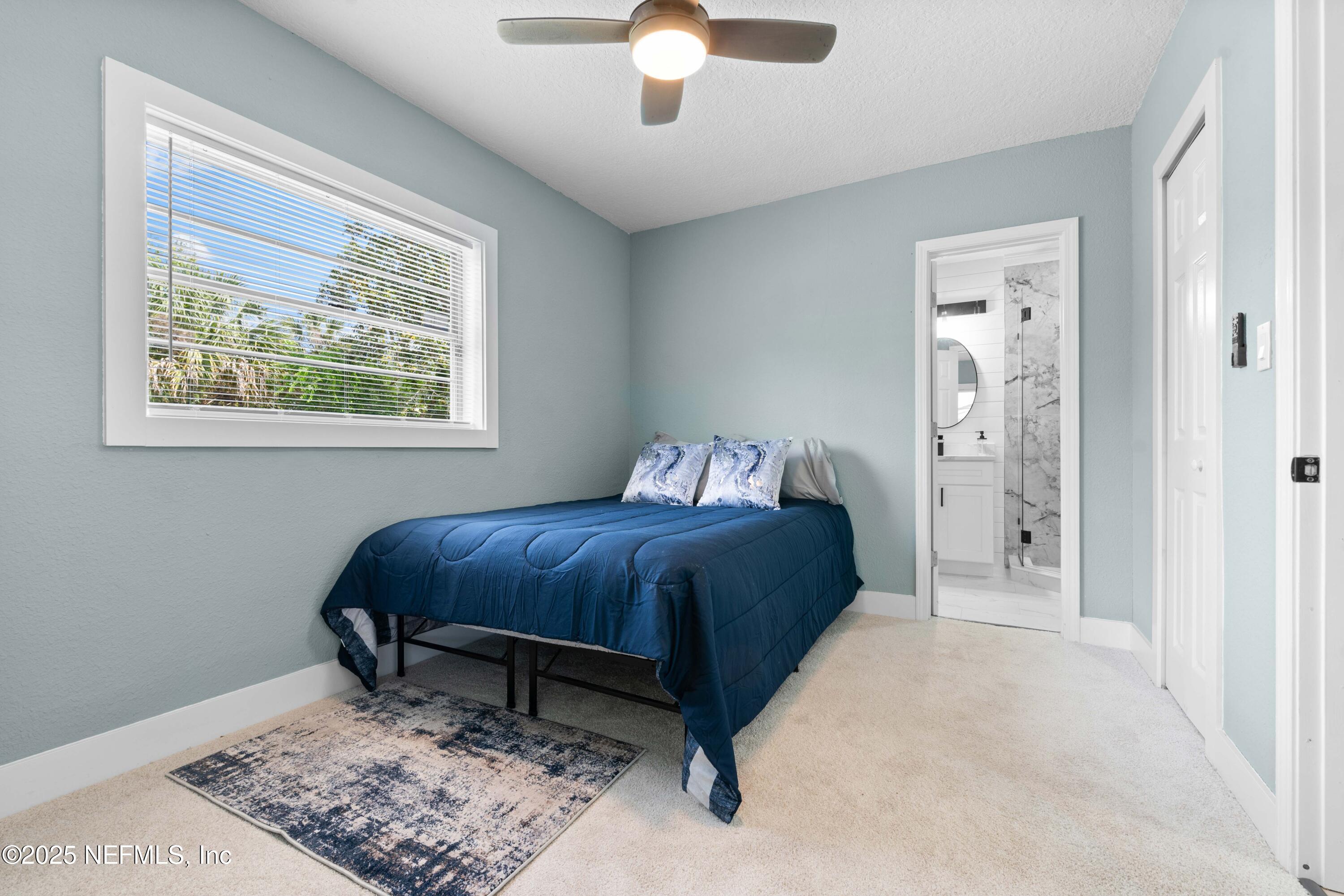 4647 Timuquana Road Jacksonville, FL 32210 - Photo 16 of 27 a bedroom with a bed and a chandelier