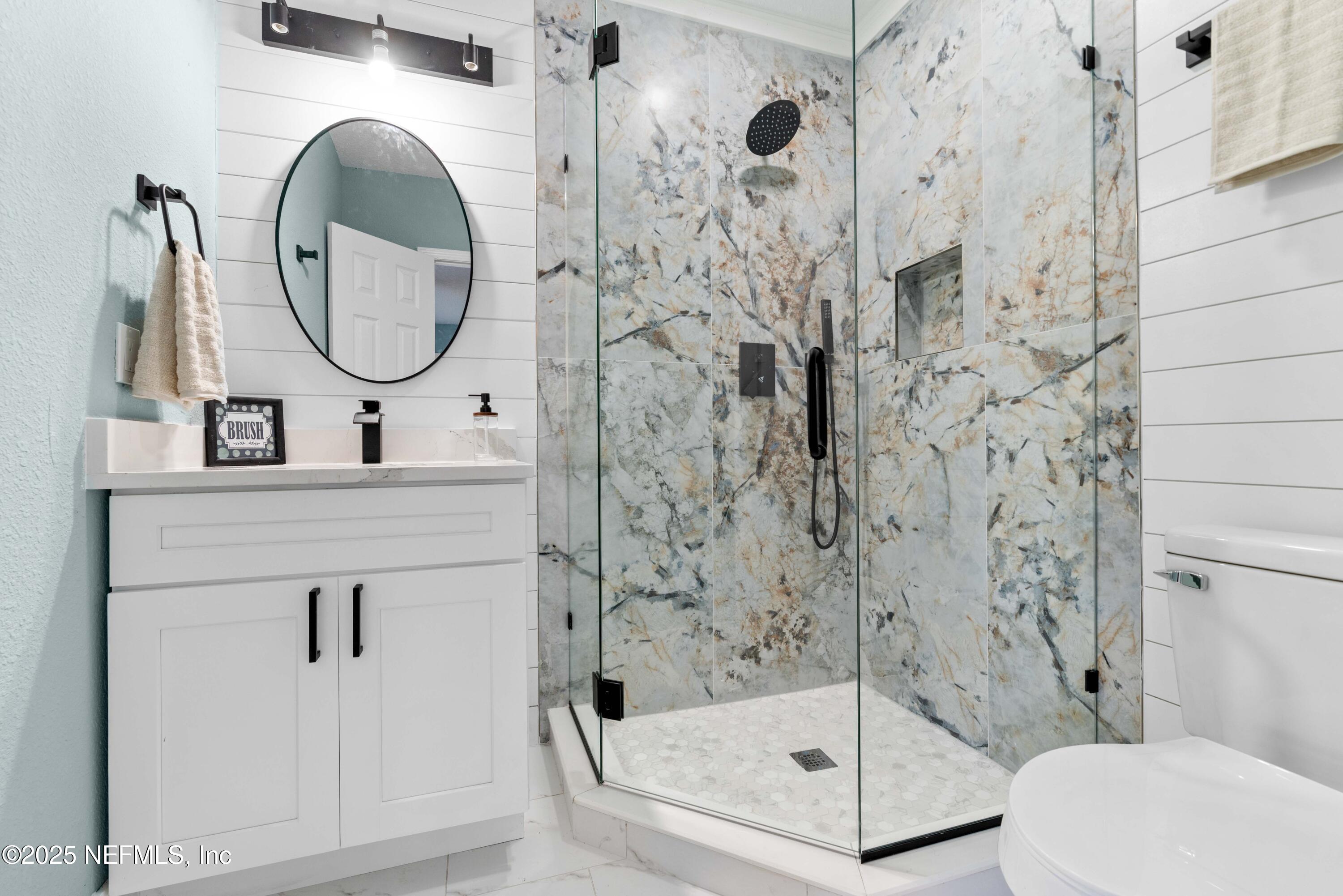 4647 Timuquana Road Jacksonville, FL 32210 - Photo 17 of 27 a bathroom with a sink a mirror a toilet and shower