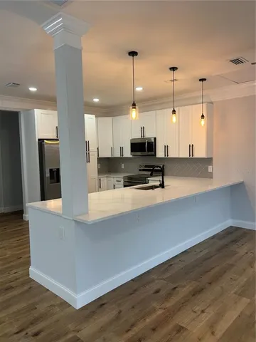 a view of kitchen with stainless steel appliances refrigerator oven and cabinets