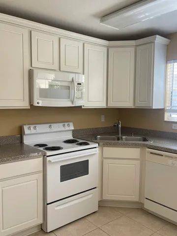 a kitchen with white cabinets and white appliances