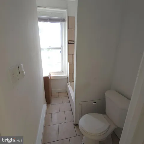 a white toilet sitting next to a window