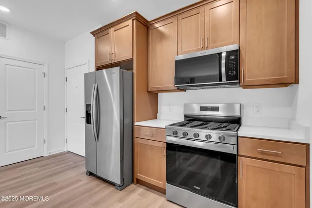 a kitchen with stainless steel appliances a stove a microwave and a refrigerator