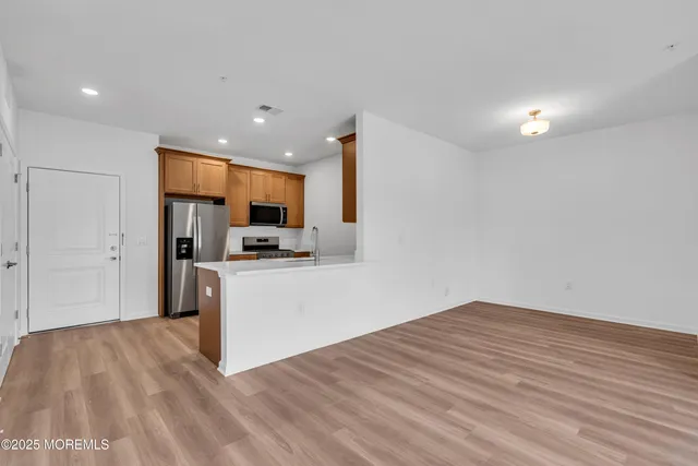 a view of kitchen with stainless steel appliances granite countertop a refrigerator and a sink