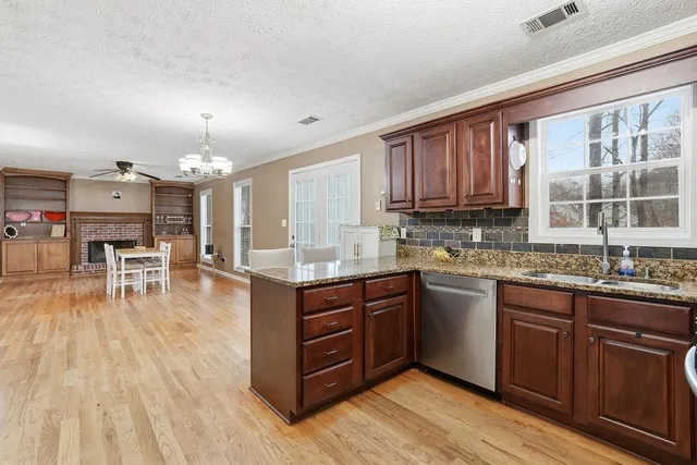 a kitchen with a sink cabinets and wooden floor