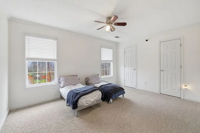a spacious bedroom with a bed a window and closet