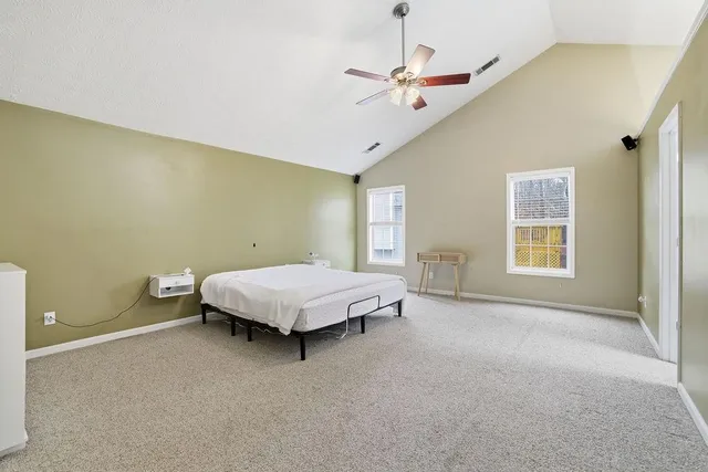 a spacious bedroom with a bed and a chandelier