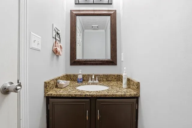 a bathroom with a granite countertop sink and a mirror