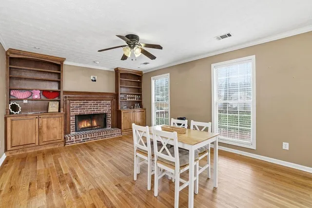 a dining room with furniture a fireplace and wooden floor