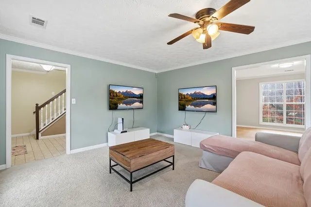 a living room with furniture a ceiling fan and a window