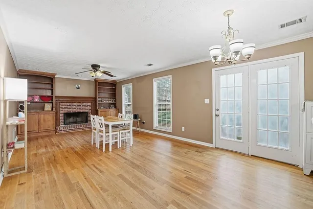 a view of a livingroom with furniture wooden floor fireplace and windows