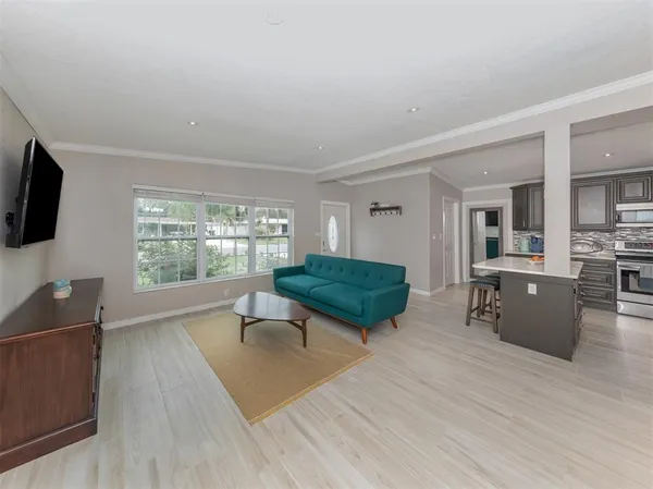 a living room with furniture a flat screen tv and a large window