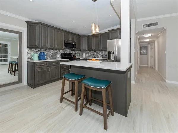a kitchen with a sink a stove cabinets and wooden floor