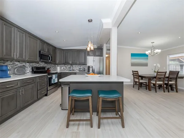 a kitchen with a dining table chairs and white cabinets