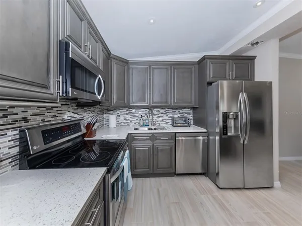 a kitchen with stainless steel appliances granite countertop a stove a refrigerator and a microwave