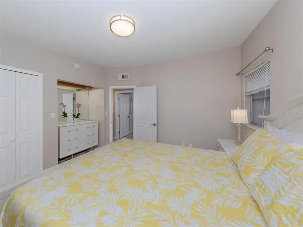 a bedroom with a large bed and a view of kitchen