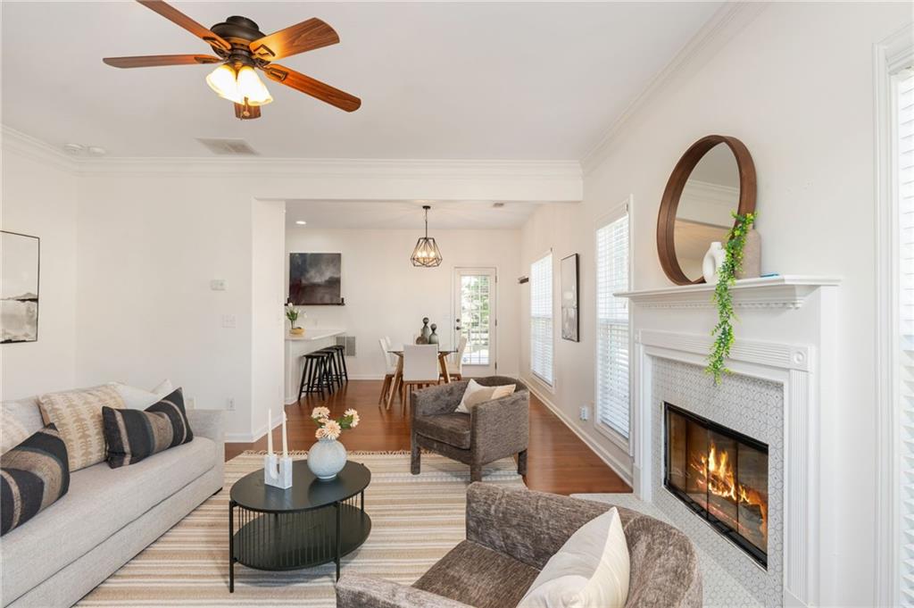 4150 Lake Pass Lane Suwanee, GA 30024 - Photo 12 of 46 a living room with furniture a fireplace and a ceiling fan