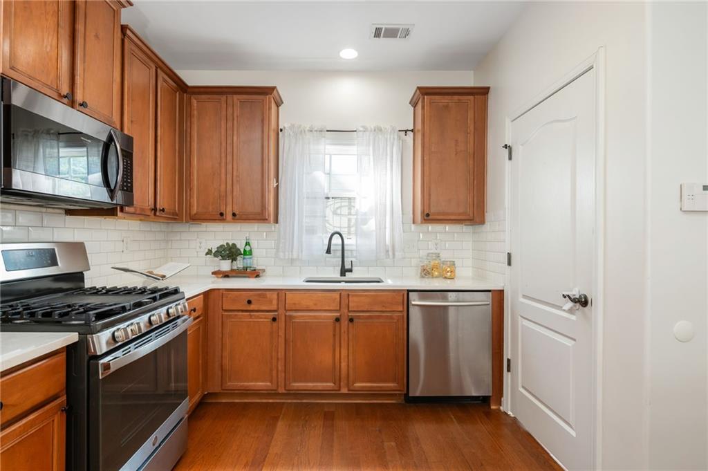 4150 Lake Pass Lane Suwanee, GA 30024 - Photo 18 of 46 a kitchen with stainless steel appliances a sink cabinets and wooden floor