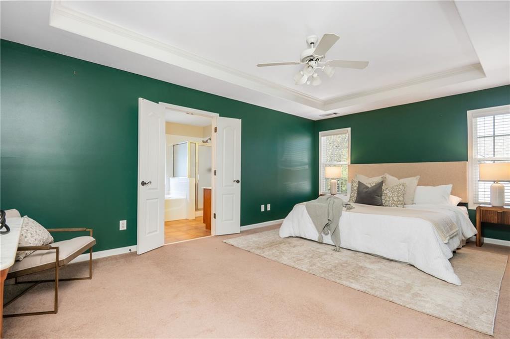 4150 Lake Pass Lane Suwanee, GA 30024 - Photo 25 of 46 a spacious bedroom with a bed and a chandelier