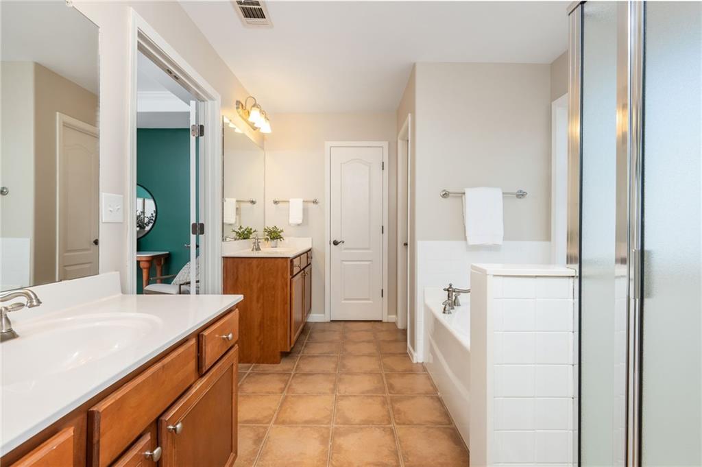 4150 Lake Pass Lane Suwanee, GA 30024 - Photo 30 of 46 a large bathroom with a double vanity sink and a mirror