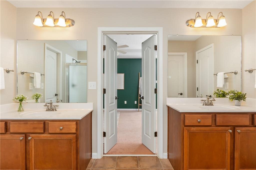 4150 Lake Pass Lane Suwanee, GA 30024 - Photo 32 of 46 a en suite bathroom with a sink double vanity and a mirror
