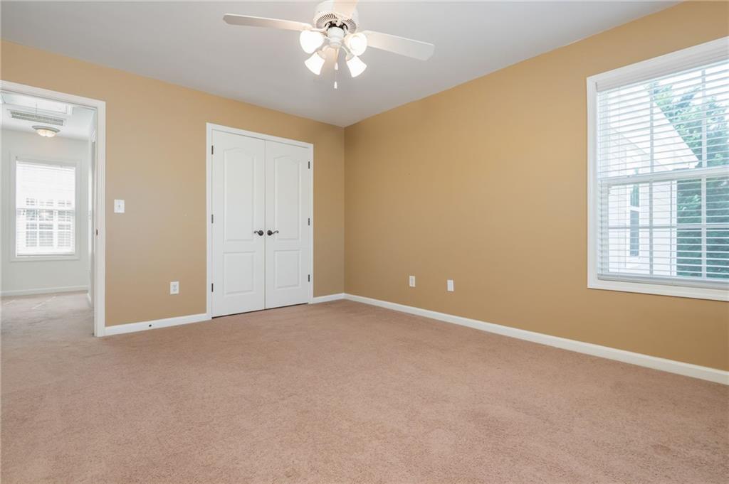 4150 Lake Pass Lane Suwanee, GA 30024 - Photo 36 of 46 an empty room with windows and chandelier fan