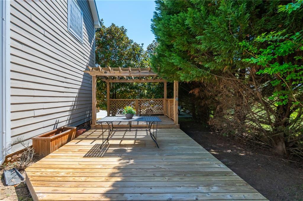 4150 Lake Pass Lane Suwanee, GA 30024 - Photo 45 of 46 a patio with table and chairs and potted plants with wooden floor and fence