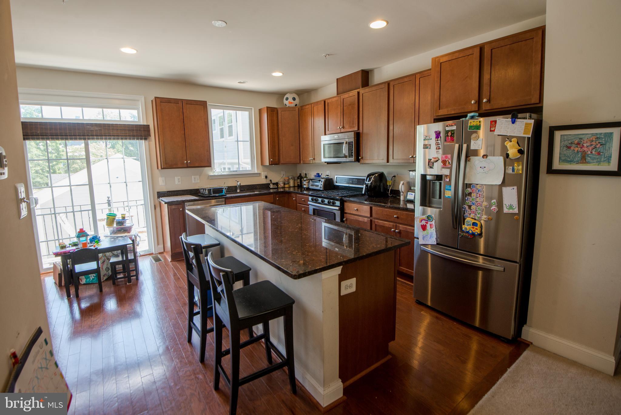 8 Meridian Lane Towson, MD 21286 - Photo 3 of 39 a kitchen with stainless steel appliances granite countertop refrigerator stove microwave and cabinets