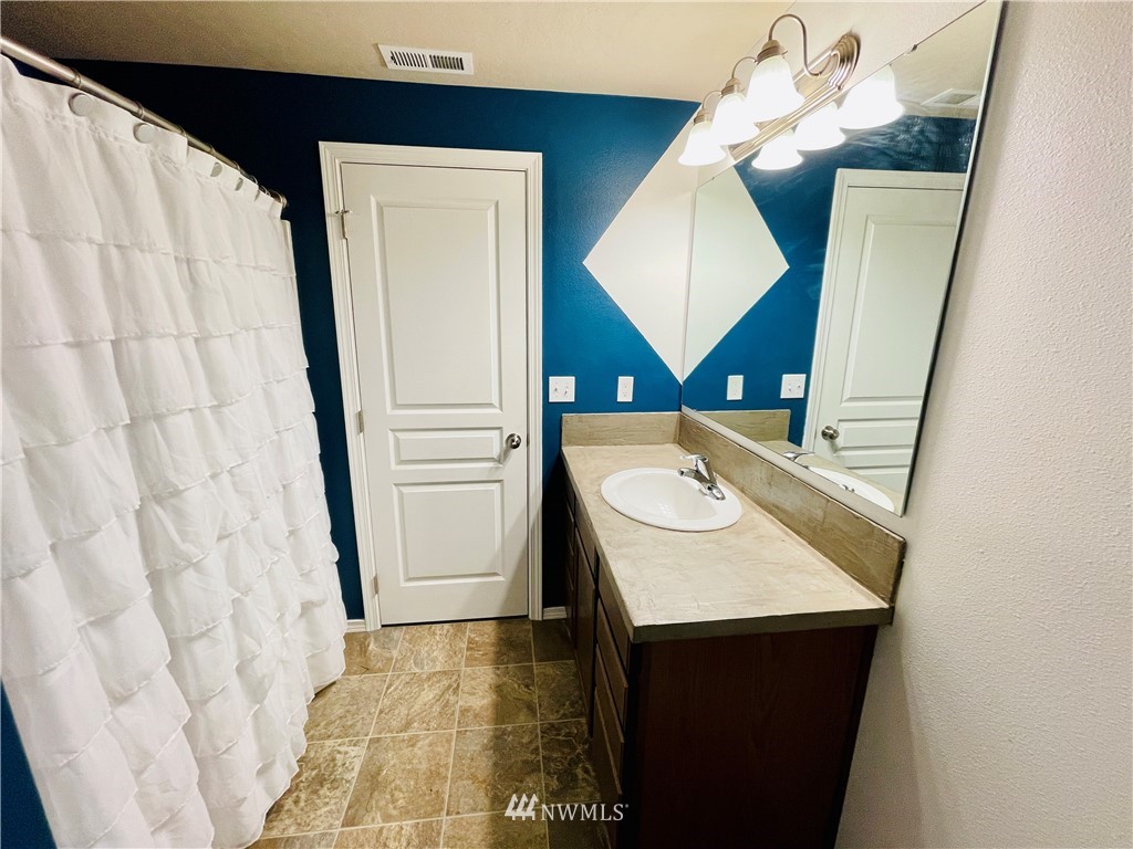 1924 Stevens Street Walla Walla, WA 99362 - Photo 17 of 24 a bathroom with a sink a mirror and shower