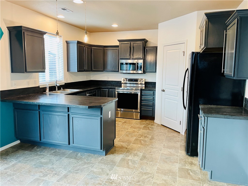 1924 Stevens Street Walla Walla, WA 99362 - Photo 6 of 24 a kitchen with stainless steel appliances granite countertop a stove a sink and a refrigerator