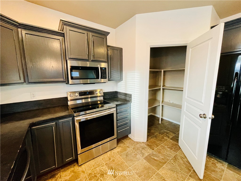 1924 Stevens Street Walla Walla, WA 99362 - Photo 8 of 24 a kitchen with a stove microwave and refrigerator