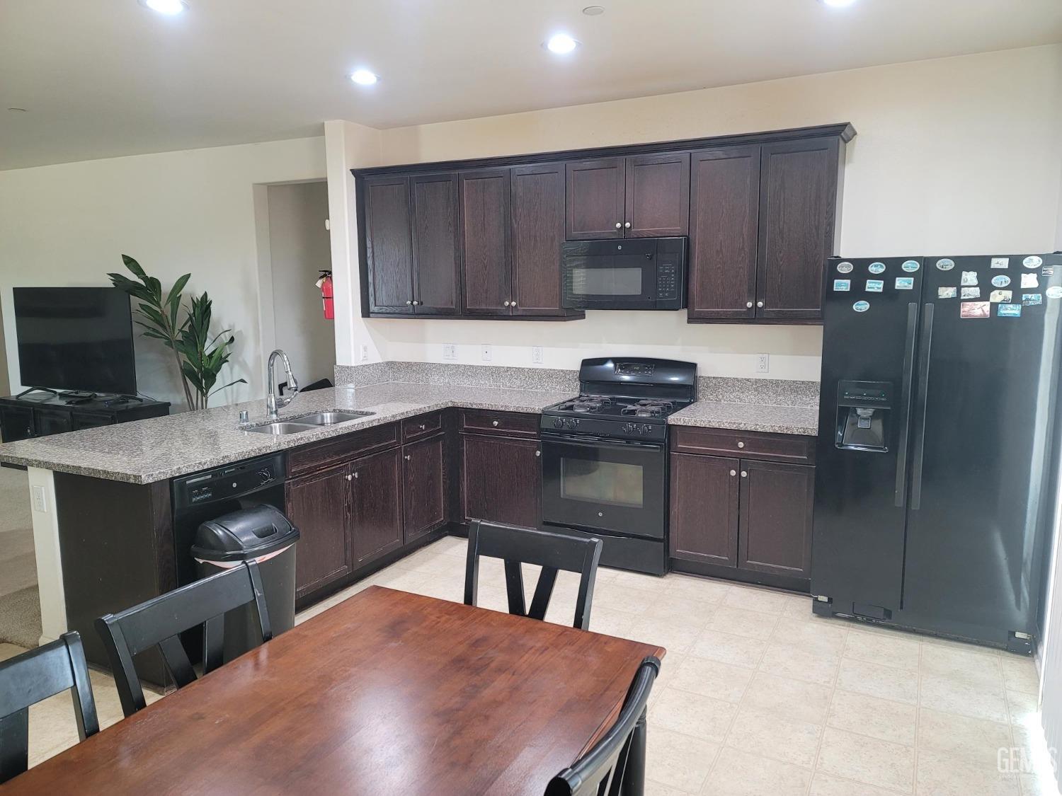 Undisclosed Address Arvin, CA 93203 - Photo 5 of 7 a kitchen with kitchen island granite countertop a sink appliances and cabinets