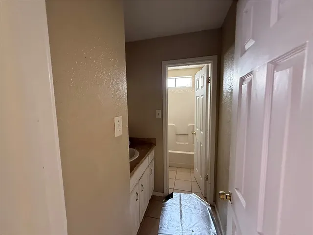 a view of a hallway with wooden floor and closet